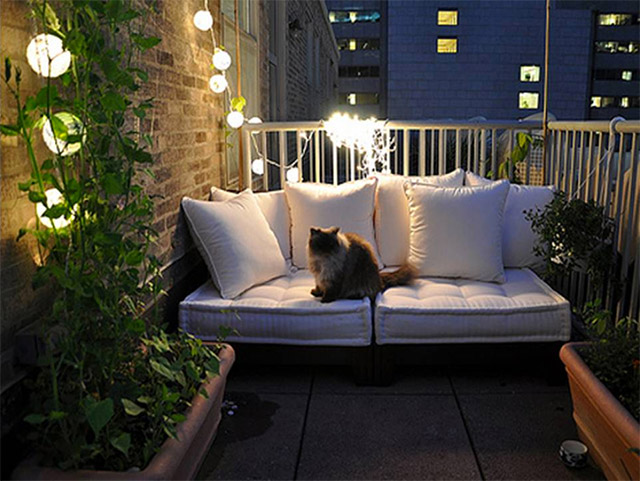 balcn con un sof de dos cuerpos de cojines blancos y un gato encima jardineras - Iluminacion Terrazas balcn con un sof de dos cuerpos de cojines blancos y un gato encima jardineras - Iluminacion Terrazas