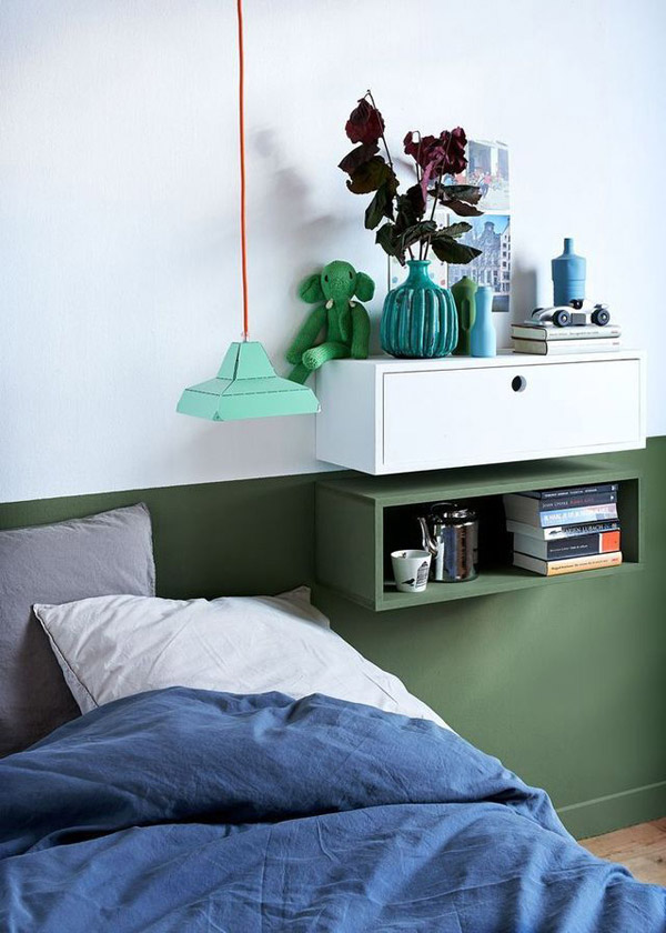 Dormitorio con paredes bicolor verde y blanco. Sobre la pared, dos repisas tipo cajón, una abierta y otra cerrada que toman los colores de la parte de la pared según donde se encuentran, la repisa abierta es verde y la otra blanca.