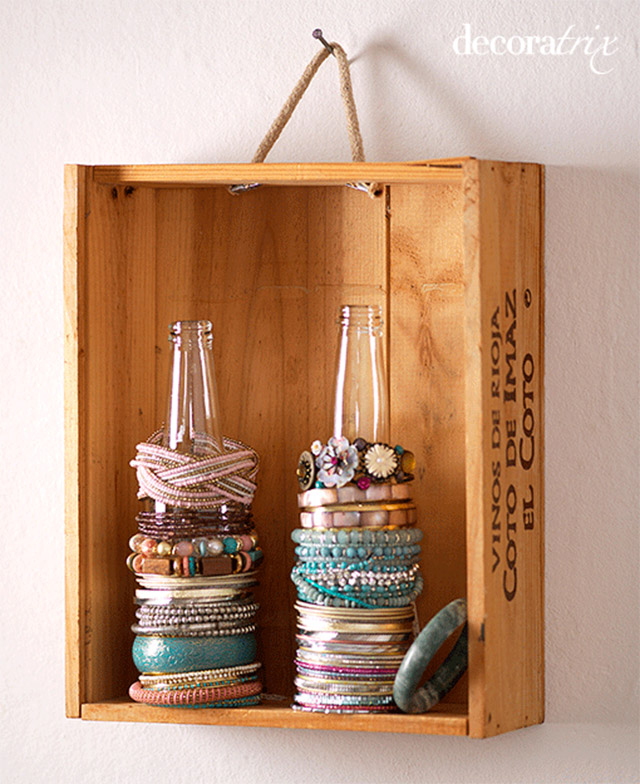 Puedes utilizar objetos que sirven para otras cosas, como botellas, pomos de puertas o cajones y hasta tablillas de madera de las que sirven para escribir. Acá vemos botellas para ordenar tus pulseras.