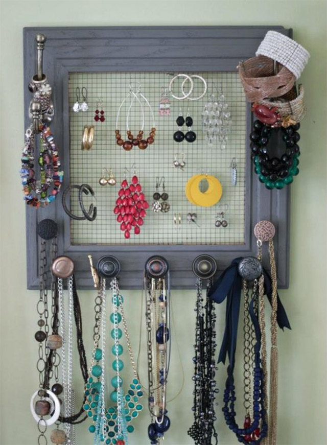 Marco de foto con malla de fondo y perchas por los bordes. En la malla tus aros y en los bordes tus collares.