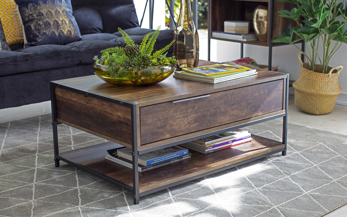 Detalle de la mesa de centro. Se ve la estructura metálica color negro combinando con la madera que compone el mueble. Su tono envejecido pero de líneas limpias y simples lo hace un gran complemento para el espacio.