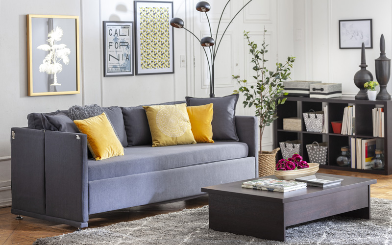 Living con sofá gris y mesa de centro de madera. Muebles multifuncionales cerrados.
