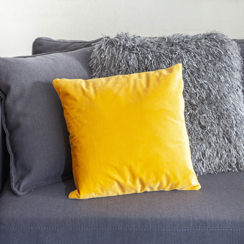 Cojín amarillo sobre sofá gris. A veces un elemento de color marca la diferencia decorativa.