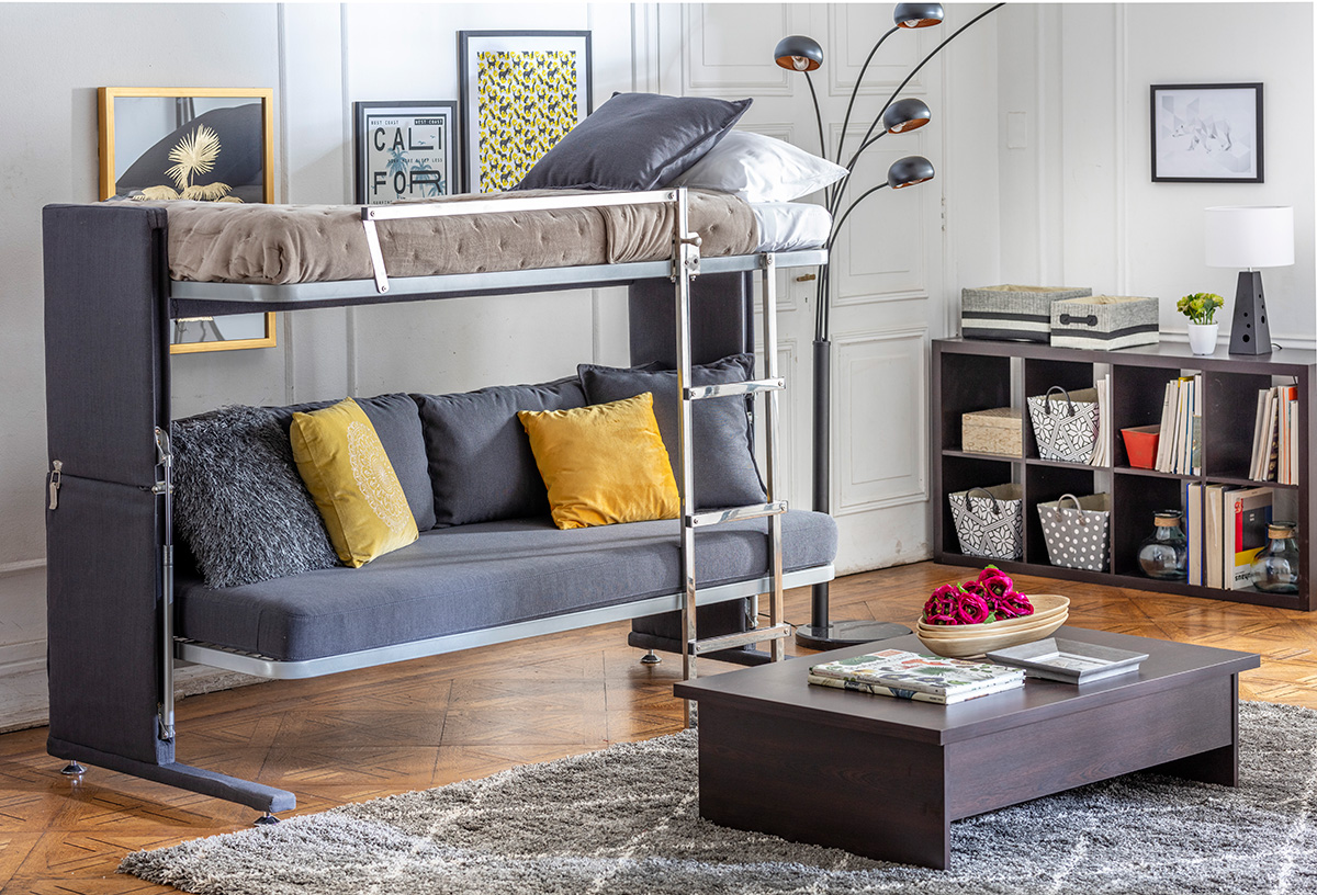 Espacio de living con sillón multifuncional abierto, formando cama tipo camarote.