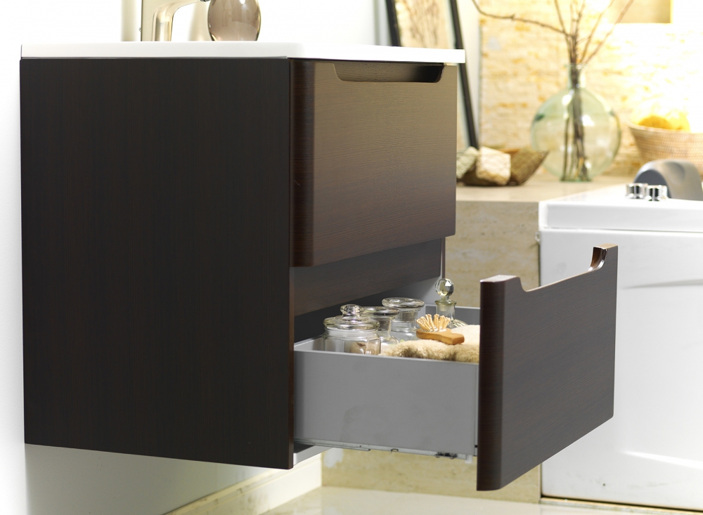Cajón bajo lavamanos con elementos decorativos como toalla, velas y cepillo
