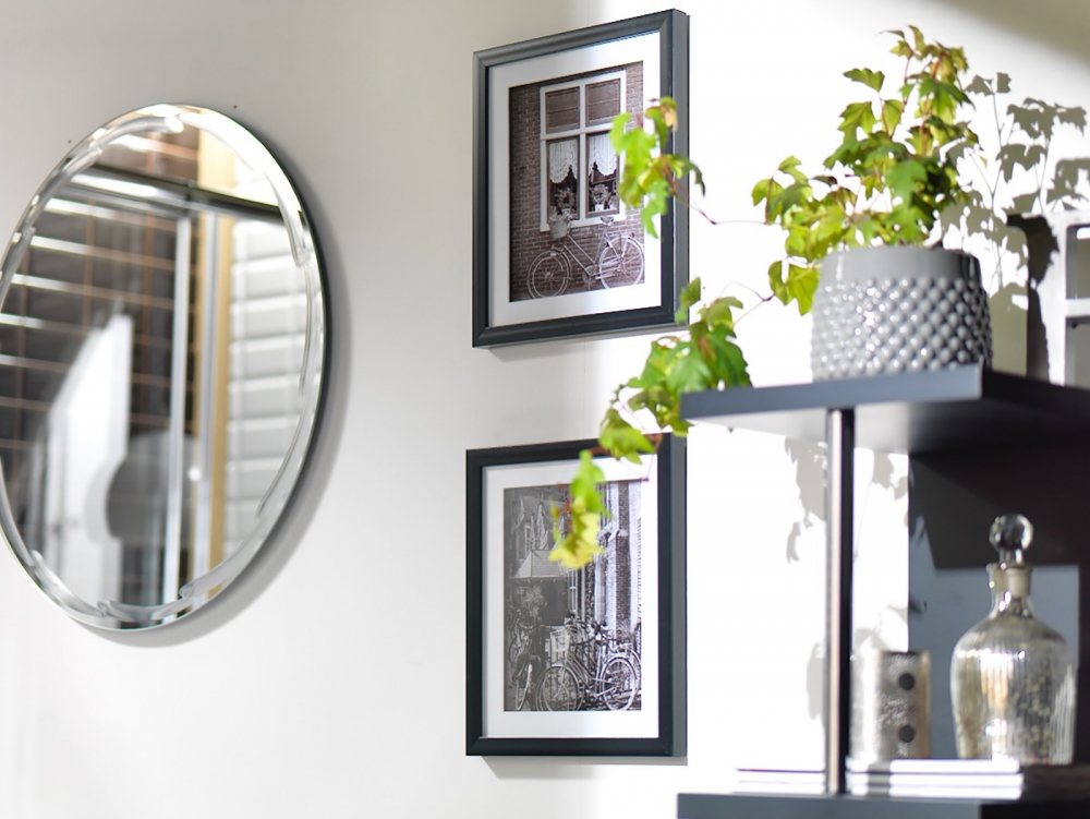 Elementos decorativos como espejos, plantas y cuadros para el baño