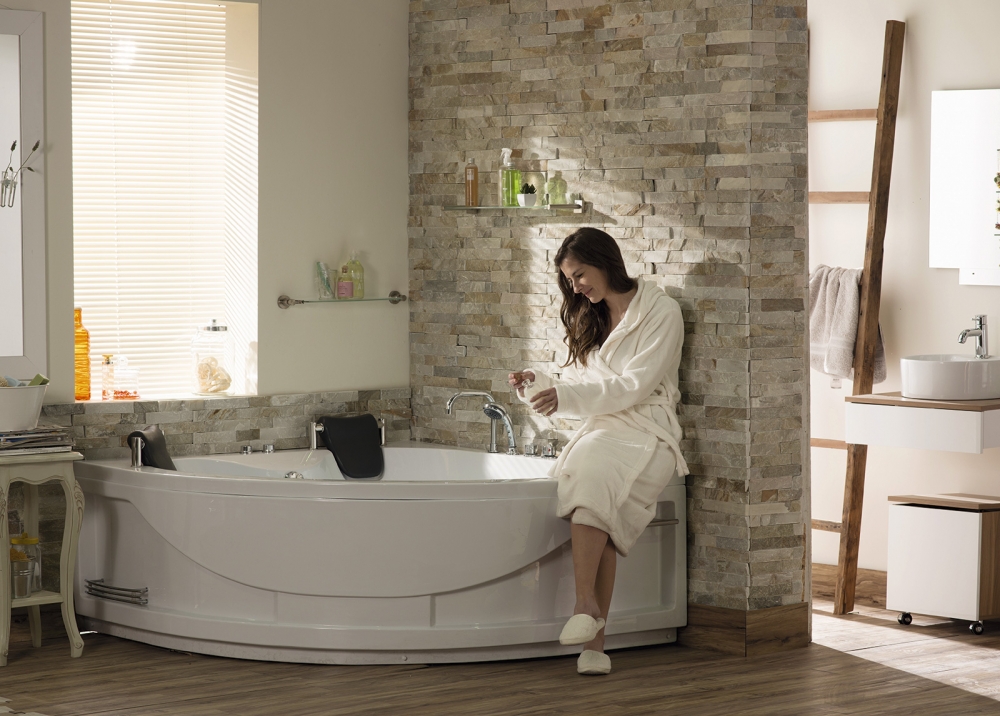Mujer sentada sobre tina de hidromasaje en baño con estilo mediterráneo